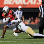 
              Cincinnati wide receiver Tre Tucker carries the ball as he is tackled by South Florida cornerback T-Mac Simpson (33) during the first half of an NCAA college football game, Saturday, Oct. 8, 2022, in Cincinnati. (AP Photo/Aaron Doster)
            