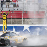 
              Christopher Bell (20) celebrates on top of his car after winning a NASCAR Cup Series auto race at Charlotte Motor Speedway, Sunday, Oct. 9, 2022, in Concord, N.C. (AP Photo/Matt Kelley)
            