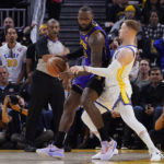 
              Golden State Warriors guard Donte DiVincenzo, right, defends against Los Angeles Lakers forward LeBron James, left, during the first half of an NBA basketball game in San Francisco, Tuesday, Oct. 18, 2022. (AP Photo/Godofredo A. Vásquez)
            