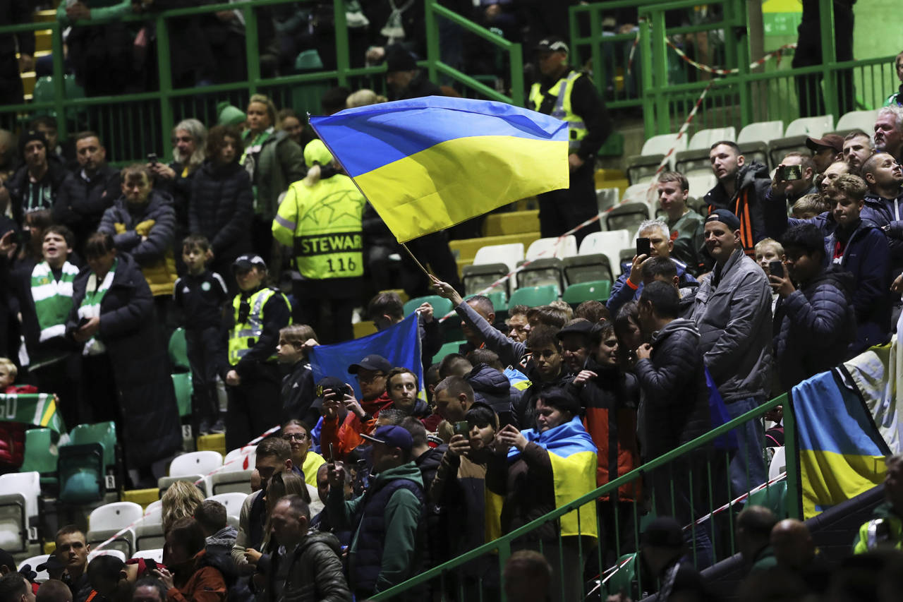 Spectators wave Ukrainian flag before the start of the Champions League Group F soccer match betwee...