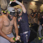 
              Atlanta Braves relief pitcher Kenley Jansen, left, is doused with champagne as players celebrate in the club house after they clinched their fifth consecutive NL East title by defeating the Miami Marlins 2-1, in a baseball game, Tuesday, Oct. 4, 2022, in Miami. (AP Photo/Wilfredo Lee)
            