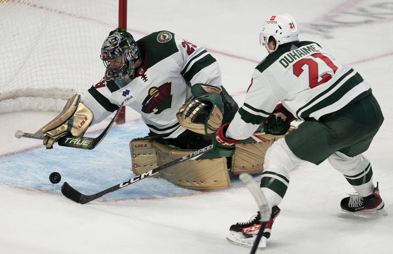 Minnesota Wild right wing Brandon Duhaime reaches for a loose puck as goaltender Marc-Andre Fleury ...