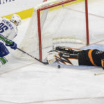 
              Philadelphia Flyers goaltender Carter Hart (79) dives on a shot on goal by Vancouver Canucks center Elias Pettersson as Andrei Kuzmenko (96) moves in during the second period of an NHL hockey game, Saturday, Oct. 15, 2022, in Philadelphia. (AP Photo/Laurence Kesterson)
            