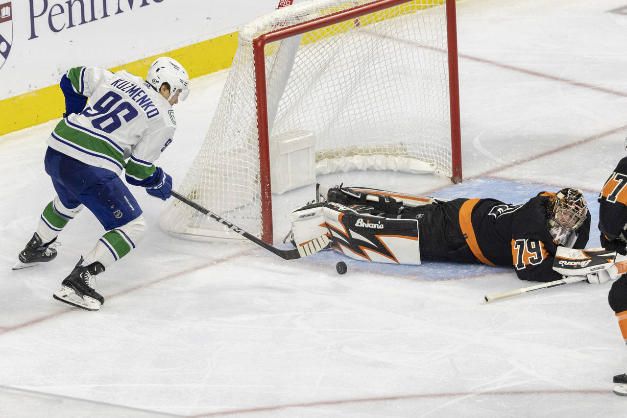 Philadelphia Flyers goaltender Carter Hart (79) dives on a shot on goal by Vancouver Canucks center...