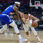 
              Phoenix Suns guard Devin Booker, right, drives past Los Angeles Clippers forward Marcus Morris Sr., during the first half of an NBA basketball game, Sunday, Oct. 23, 2022 in Los Angeles. (AP Photo/Alex Gallardo)
            