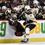 
              Boston Bruins center Trent Frederic (11) sends Ottawa Senators right wing Alex DeBrincat (12) into the boards during the first period of an NHL hockey game Tuesday, Oct. 18, 2022, in Ottawa, Ontario. (Justin Tang/The Canadian Press via AP)
            