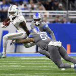 
              Miami Dolphins wide receiver Cedrick Wilson Jr. (11) pulls away from Detroit Lions linebacker Josh Woods (51) during the second half of an NFL football game, Sunday, Oct. 30, 2022, in Detroit. (AP Photo/Lon Horwedel)
            