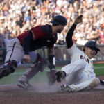 
              San Francisco Giants' Wilmer Flores, right, slides home to score the winning run against Arizona Diamondbacks catcher Carson Kelly during the 10th inning of a baseball game in San Francisco, Sunday, Oct. 2, 2022. (AP Photo/Jeff Chiu)
            