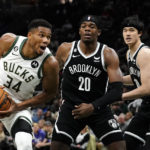 
              Milwaukee Bucks' Giannis Antetokounmpo (34) drives to the basket against Brooklyn Nets' Day'Ron Sharpe (20) and Yuta Watanabe during the second half of an NBA preseason basketball game Wednesday, Oct. 12, 2022, in Milwaukee. (AP Photo/Aaron Gash)
            