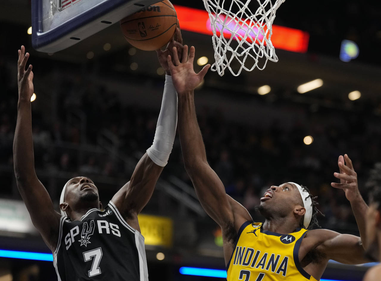 Indiana Pacers guard Buddy Hield , right, fights for a rebound against San Antonio Spurs guard Josh...