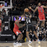 
              Chicago Bulls forward Derrick Jones Jr. (5) defends San Antonio Spurs guard Blake Wesley (14) during the second half of an NBA basketball game, Friday, Oct. 28, 2022, in San Antonio. (AP Photo/Nick Wagner)
            