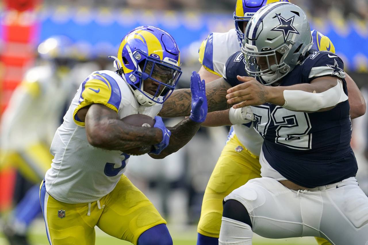 Los Angeles Rams running back Cam Akers (3) fights off a tackle attempt by Dallas Cowboys defensive...