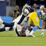 
              Los Angeles Chargers running back Austin Ekeler, right, is hit by Denver Broncos cornerback Damarri Mathis, center, during the first half of an NFL football game, Monday, Oct. 17, 2022, in Inglewood, Calif. (AP Photo/Mark J. Terrill)
            
