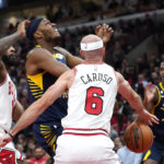 
              Chicago Bulls' Alex Caruso (6) slaps the ball away from Indiana Pacers' Myles Turner as Andre Drummond also defends during the first half of an NBA basketball game Wednesday, Oct. 26, 2022, in Chicago. (AP Photo/Charles Rex Arbogast)
            