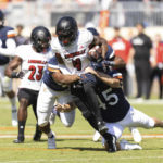 
              Louisville's Braden Smith is tackled from behind by Virginia defenders during an NCAA college football game in Charlottesville, Va., Saturday, Oct. 8, 2022. (Mike Kropf/The Daily Progress via AP)
            