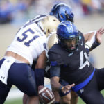 
              Air Force quarterback Haaziq Daniels, front, fumbles the ball as he is hit by Navy linebackers John Marshall, center, and Nicholas Straw in the first half of an NCAA college football game Saturday, Oct. 1, 2022, at Air Force Academy, Colo. (AP Photo/David Zalubowski)
            