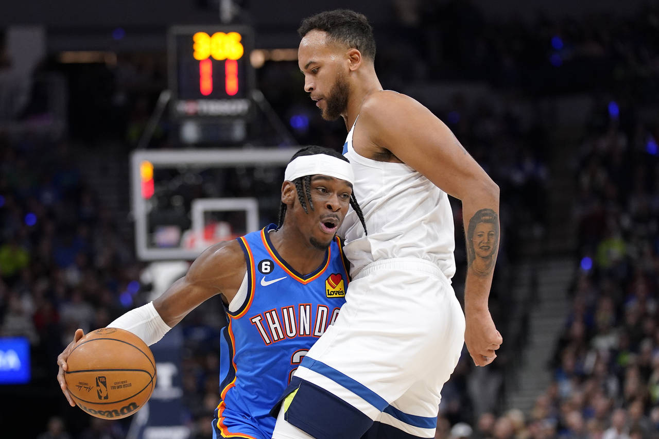 Oklahoma City Thunder guard Shai Gilgeous-Alexander (2) is defended by Minnesota Timberwolves forwa...
