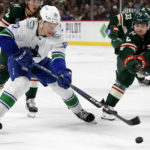 
              Vancouver Canucks right wing Vasily Podkolzin (92) and Minnesota Wild defenseman Calen Addison (2) compete for the puck during the second period of an NHL hockey game Thursday, Oct. 20, 2022, in St. Paul, Minn. (AP Photo/Andy Clayton-King)
            