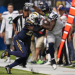 
              Los Angeles Chargers cornerback J.C. Jackson (27) pushes Seattle Seahawks running back Kenneth Walker III (9) out of bounds during the first half of an NFL football game Sunday, Oct. 23, 2022, in Inglewood, Calif. (AP Photo/Mark J. Terrill)
            