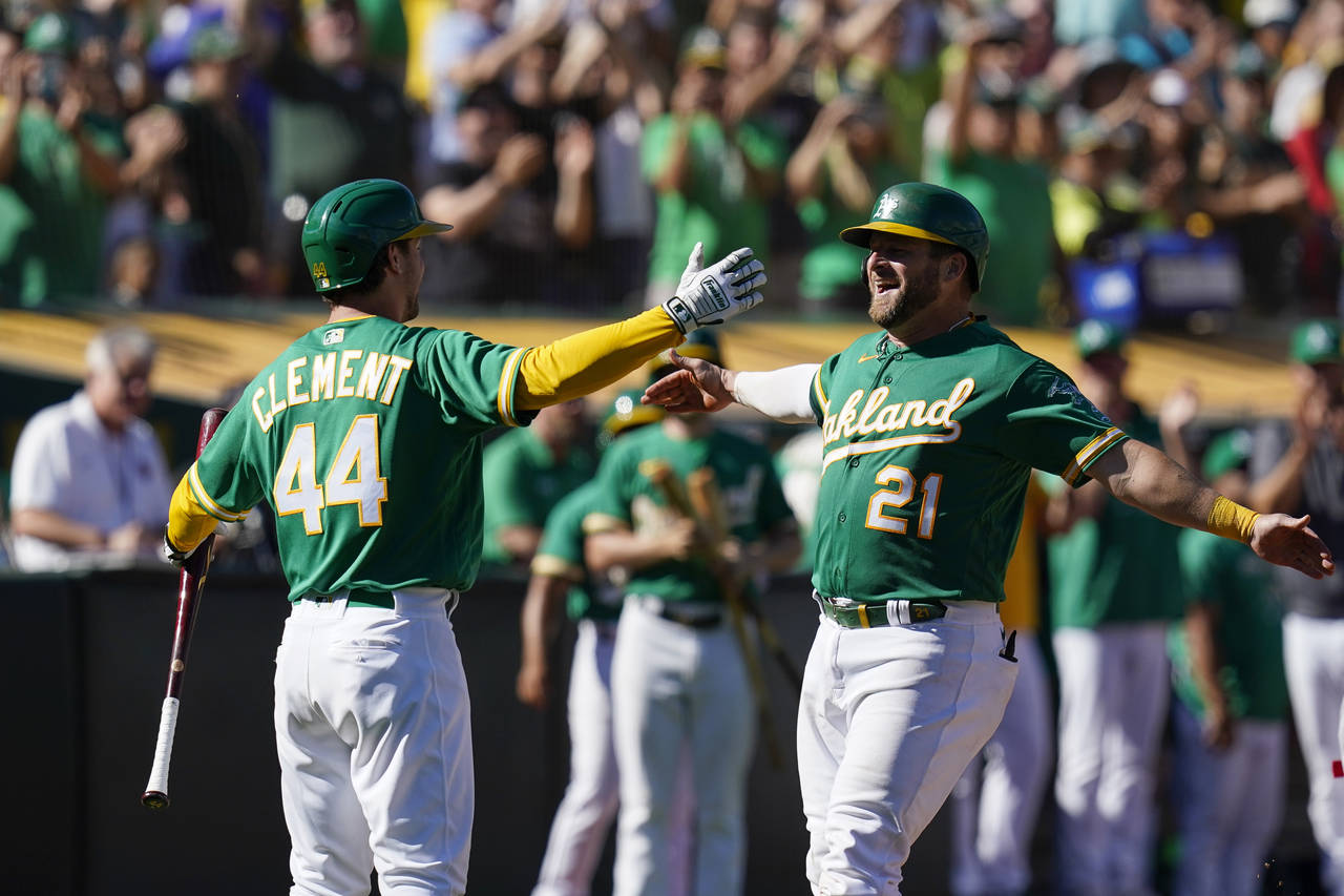 Oakland Athletics' Stephen Vogt (21) celebrates with Ernie Clement (44) after hitting a solo home r...