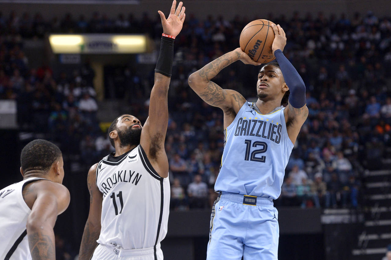 Memphis Grizzlies guard Ja Morant (12) shoots against Brooklyn Nets guard Kyrie Irving (11) in the ...