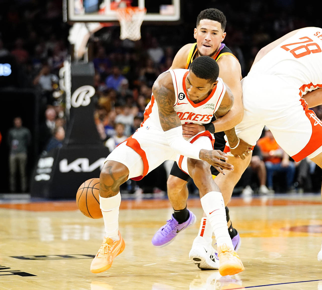 Phoenix Suns' Devin Booker, top, knocks the ball away from Houston Rockets' Kevin Porter Jr., botto...