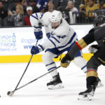 
              Toronto Maple Leafs defenseman Morgan Rielly (44) and Vegas Golden Knights defenseman Zach Whitecloud (2) vie for the puck during the first period of an NHL hockey game Monday, Oct. 24, 2022, in Las Vegas. (AP Photo/Steve Marcus)
            