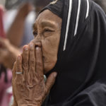 
              A woman offers prayer outside Kanjuruhan Stadium where a soccer stampede killed more than 100 people on Saturday, in Malang, East Java, Indonesia, Tuesday, Oct. 4, 2022. An Indonesian police chief and nine elite officers were removed from their posts Monday and 18 others were being investigated for responsibility in the firing of tear gas inside a soccer stadium that set off a stampede, officials said. (AP Photo/Dicky Bisinglasi)
            