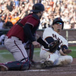 
              San Francisco Giants' Wilmer Flores, right, slides home to score the winning run against Arizona Diamondbacks catcher Carson Kelly during the 10th inning of a baseball game in San Francisco, Sunday, Oct. 2, 2022. (AP Photo/Jeff Chiu)
            