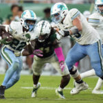 
              Tulane running back Tyjae Spears (22) heads upfield as offensive lineman Joey Claybrook (79) puts a block on South Florida linebacker Dwayne Boyles (11) during the second half of an NCAA college football game Saturday, Oct. 15, 2022, in Tampa, Fla. (AP Photo/Chris O'Meara)
            