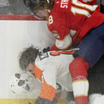 
              Florida Panthers defenseman Marc Staal (18) slams Philadelphia Flyers center Zack MacEwen into the boards during the second period of an NHL hockey game, Wednesday, Oct. 19, 2022, in Sunrise, Fla. (AP Photo/Wilfredo Lee )
            