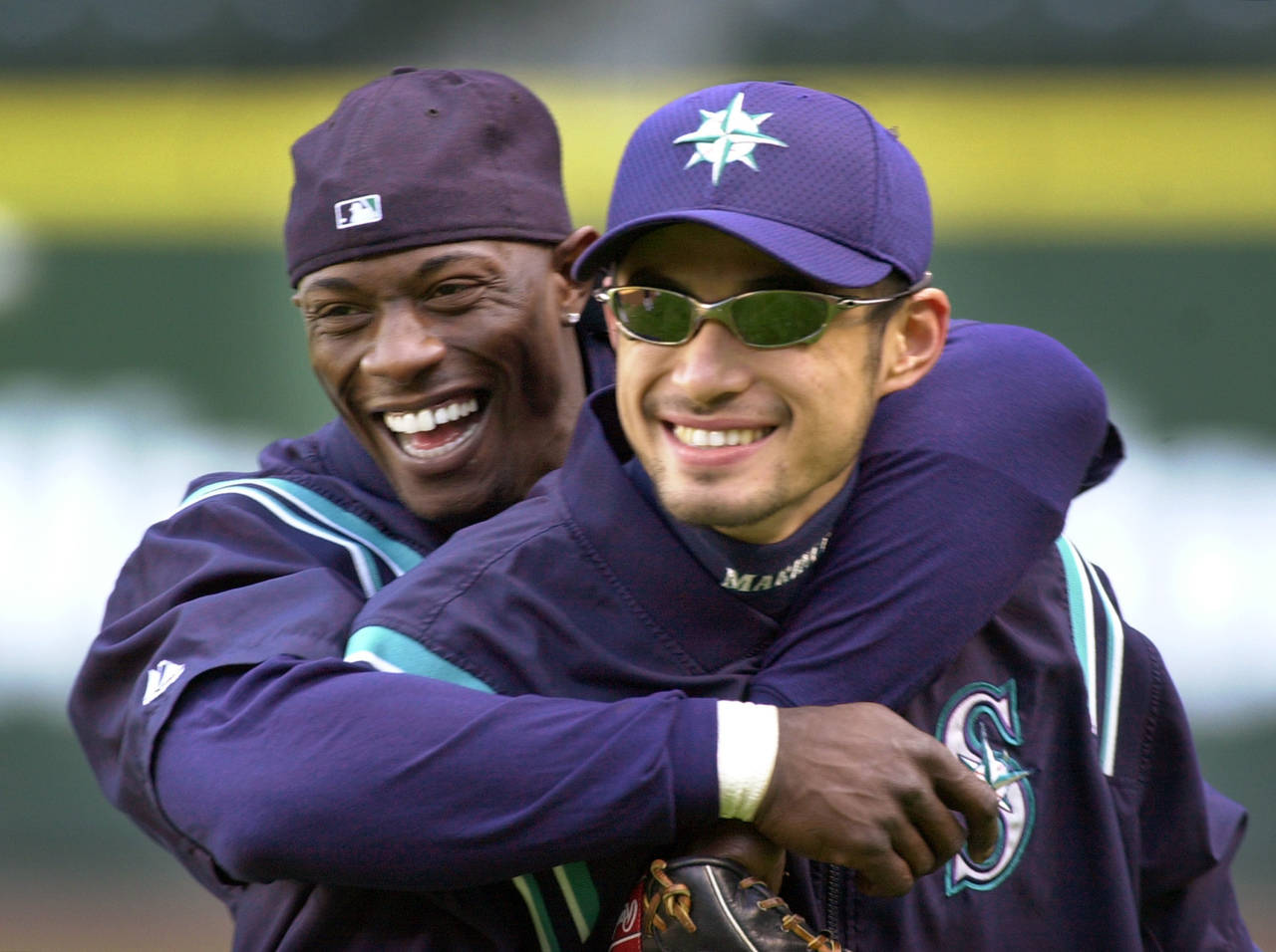 FILE - Seattle Mariners' Mike Cameron, left, embraces teammate Ichiro Suzuki during their workout M...