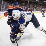 
              St. Louis Blues' Alexei Toropchenko (13) is checked by Edmonton Oilers' Tyson Barrie (22) during the third period of an NHL game in Edmonton, Alberta, Saturday, Oct. 22, 2022. (Jason Franson/The Canadian Press via AP)
            