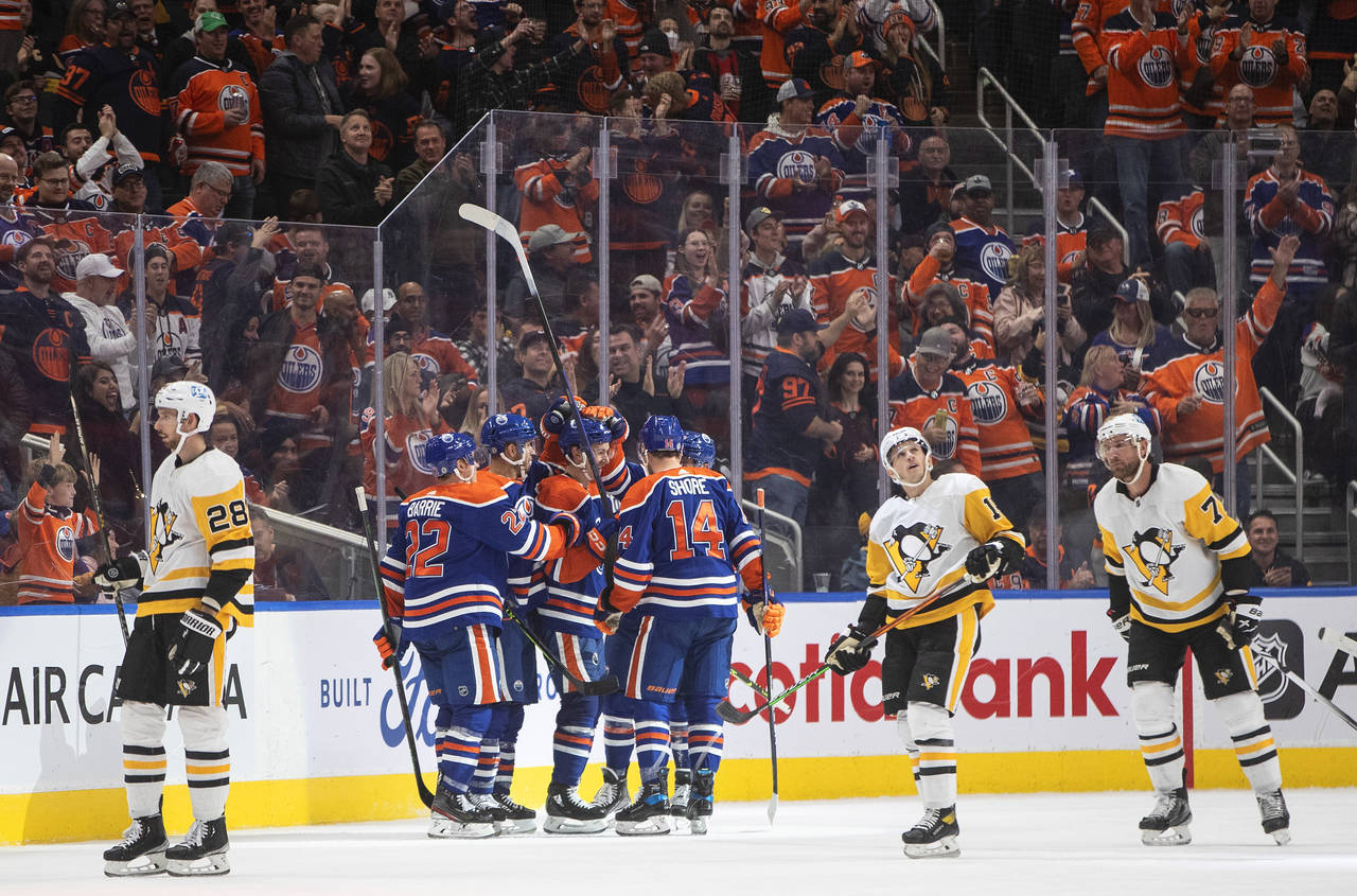 Edmonton Oilers players celebrate a goal against the Pittsburgh Penguins during third-period NHL ho...