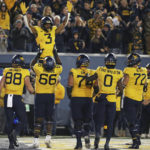 
              West Virginia players celebrate after West Virginia wide receiver Kaden Prather (3) scored a touchdown during the second half of the team's NCAA college football game against Baylor in Morgantown, W.Va., Thursday, Oct. 13, 2022. (AP Photo/Kathleen Batten)
            