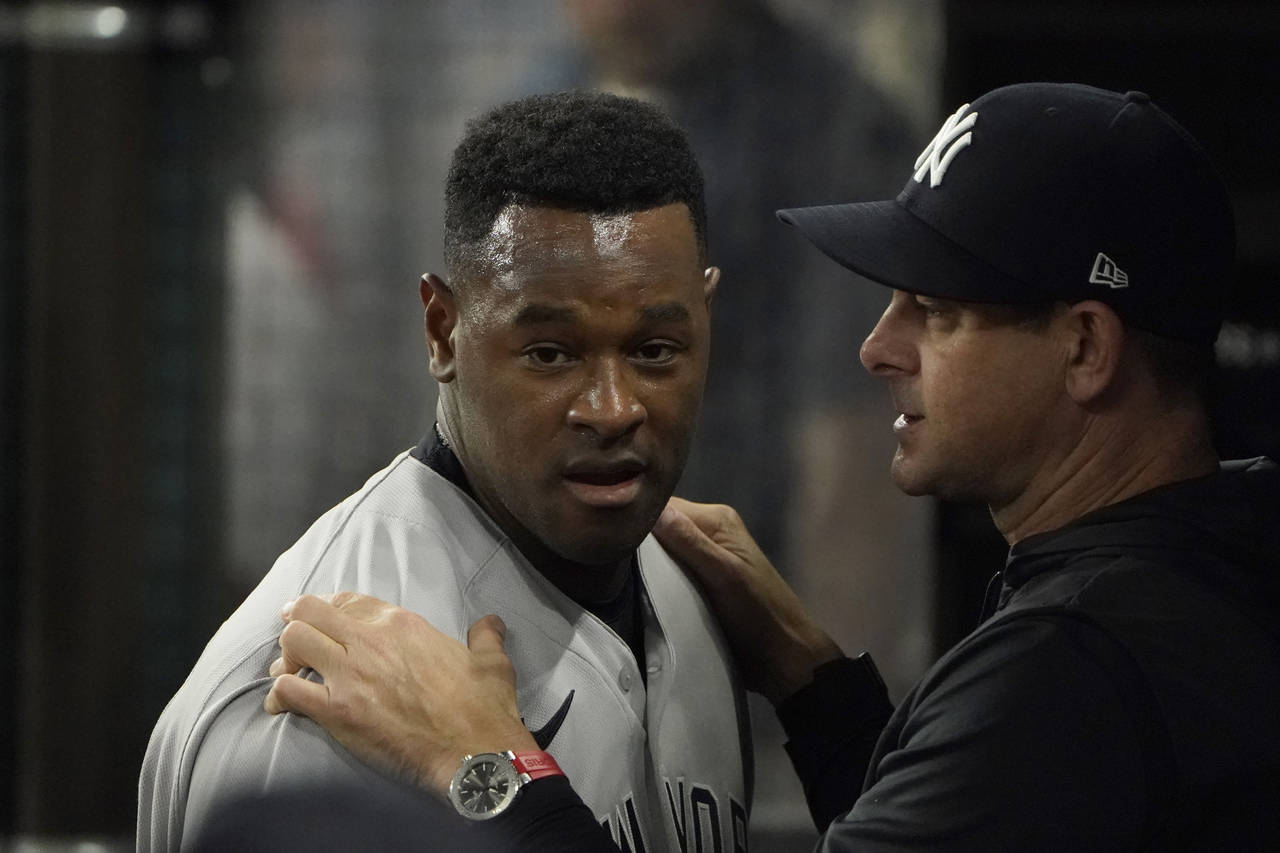 New York Yankees starting pitcher Luis Severino, left, listens to manager Aaron Boone in the dugout...