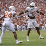 
              Texas running backs Bijan Robinson (5) and Jonathan Brooks (24) celebrates Brooks' touchdown run against Oklahoma during the second half of an NCAA college football game at the Cotton Bowl, Saturday, Oct. 8, 2022, in Dallas. Texas won 49-0. (AP Photo/Jeffrey McWhorter)
            