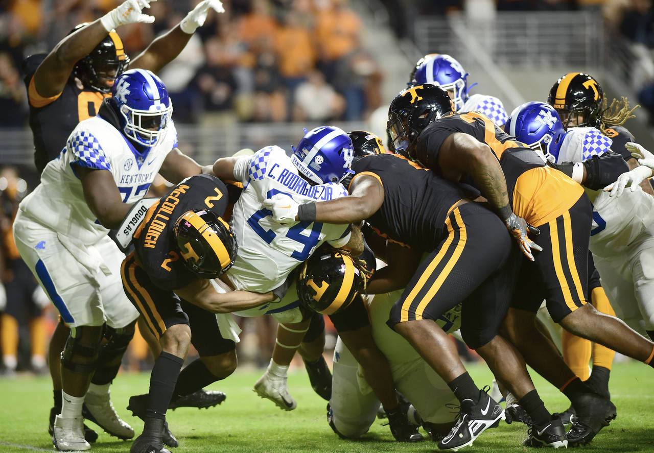 Tennessee defenders meet Wildcat runningback Chris Rodriguez (24) in the backfield during an NCAA c...