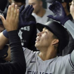 
              New York Yankees' Oswaldo Cabrera celebrates hits a solo home run in the dugout during the first inning of the first baseball game of a doubleheader in Arlington, Texas, Tuesday, Oct. 4, 2022. (AP Photo/LM Otero)
            