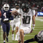 
              Oregon quarterback Bo Nix (10) scores a touchdown against Arizona in the second half during an NCAA college football game, Saturday, Oct. 8, 2022, in Tucson, Ariz. (AP Photo/Rick Scuteri)
            