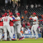 
              Philadelphia Phillies players celebrate after clinching a wild card playoff berth with a 3-0 win over the Houston Astros, Monday, Oct. 3, 2022, in Houston. (Brett Coomer/Houston Chronicle via AP)
            