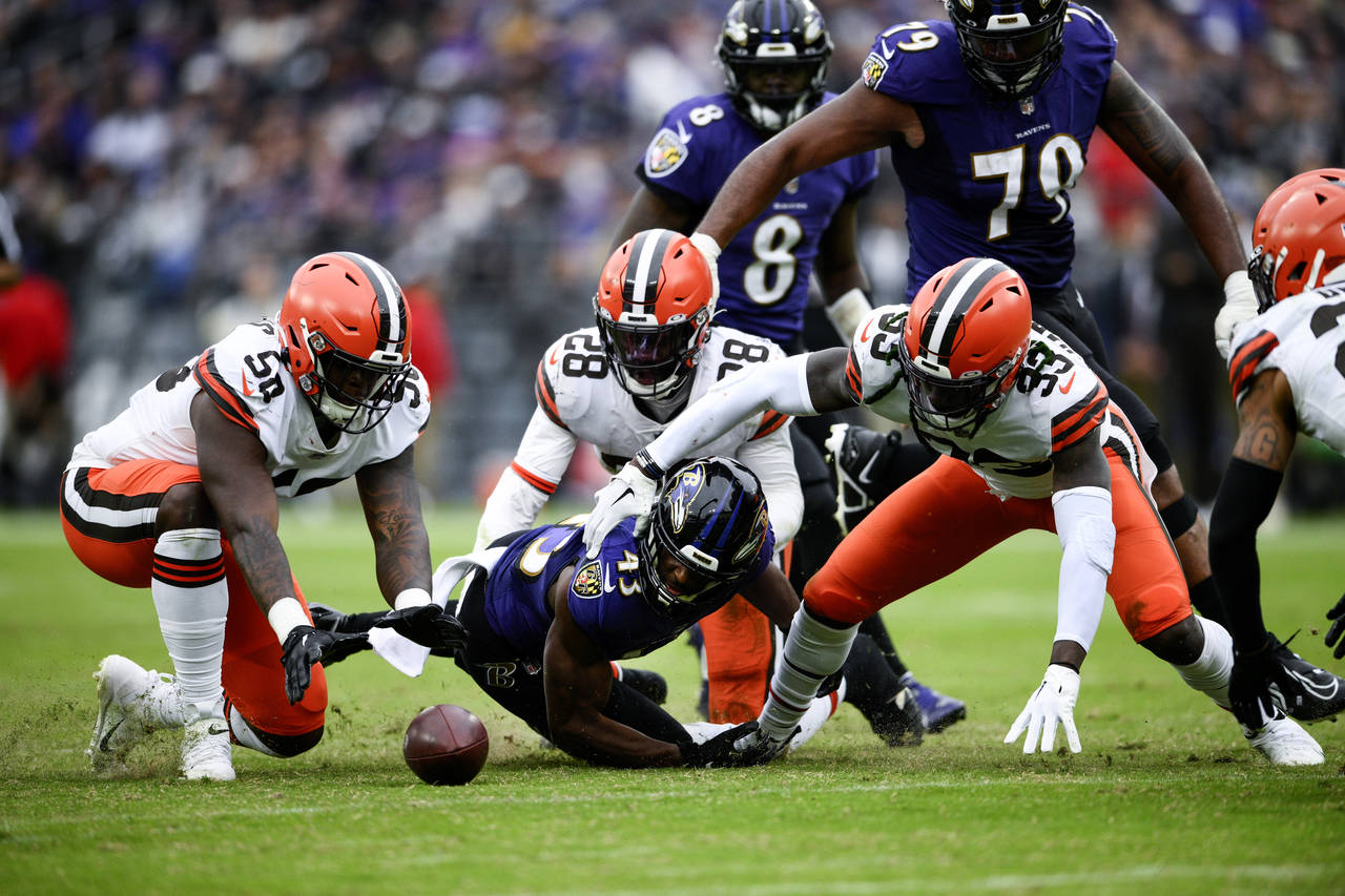 Cleveland Browns defensive end Isaiah Thomas (58) recovers Baltimore Ravens running back Justice Hi...