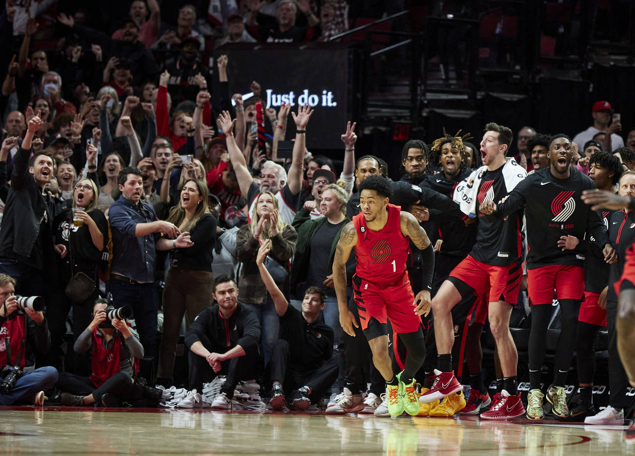 The Portland Trail Blazers' bench reacts after guard Anfernee Simons (1) made a basket against the ...