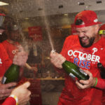 
              Philadelphia Phillies' Kyle Schwarber, right, and Rhys Hoskins celebrate after the Phillies won a baseball game against the Houston Astros to clinch a wild-card playoff spot, Monday, Oct. 3, 2022, in Houston. (AP Photo/David J. Phillip)
            