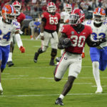 
              Georgia running back Daijun Edwards (30) runs for a 22-yard touchdown past Florida cornerback Avery Helm (24) and defensive lineman Princely Umanmielen (33) during the second half of an NCAA college football game Saturday, Oct. 29, 2022, in Jacksonville, Fla. (AP Photo/John Raoux)
            
