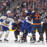 
              Edmonton Oilers' Dylan Holloway (55) gets up after a hit as Oilers and Buffalo Sabres rough it up during the second period of an NHL hockey game Tuesday, Oct. 18, 2022, in Edmonton, Alberta. (Jason Franson/The Canadian Press via AP)
            
