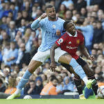 
              Manchester City's Kyle Walker, left, challenges for the ball with Manchester United's Tyrell Malacia during the English Premier League soccer match between Manchester City and Manchester United at Etihad stadium in Manchester, England, Sunday, Oct. 2, 2022. (AP Photo/Rui Vieira)
            