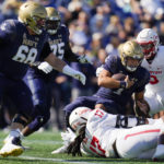 
              Navy quarterback Tai Lavatai, center right, is sacked by Houston defensive lineman Atlias Bell (17) and defensive lineman Nelson Ceaser (9) during the first half of an NCAA college football game, Saturday, Oct. 22, 2022, in Annapolis, Md. (AP Photo/Julio Cortez)
            