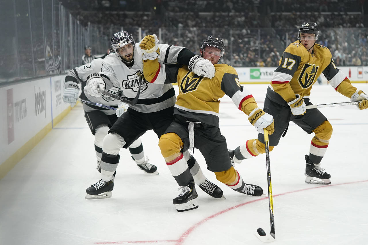 Vegas Golden Knights' Jack Eichel, center right, loses balance while being pressured by Los Angeles...