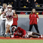 
              Florida State's Mycah Pittman (4) holds the ball after catching a touchdown pass over North Carolina State's Jakeen Harris (6) during the first half of an NCAA college football game in Raleigh, N.C., Saturday, Oct. 8, 2022. (AP Photo/Karl B DeBlaker)
            